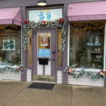 Hands On Health storefront on Genesee Street with pink awnings and holiday decorations