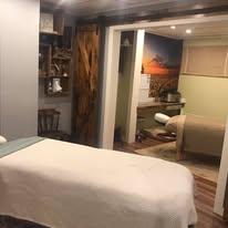Wide angle view of studio interior showing hallway and adjacent treatment room with barn wood details